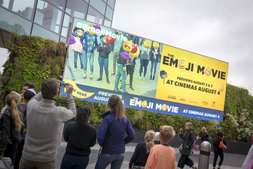 People crowd to look at The Emoji Movie's interactive campaign on Ocean’s Eat Street screen.