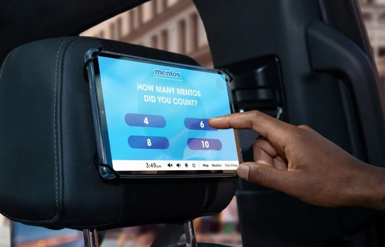 Close up of Passenger interacting with octopus tablet in the backseat of a Rideshare.